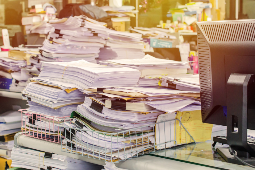 Chaos im Büro mit Papierstapeln und Unordnung