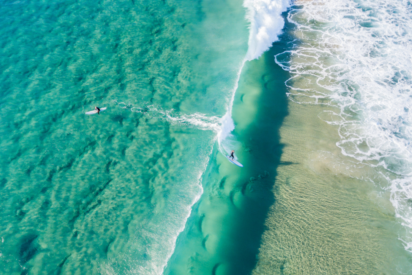 Surfer in Australien auf türkisem Meer Luftaufnahme