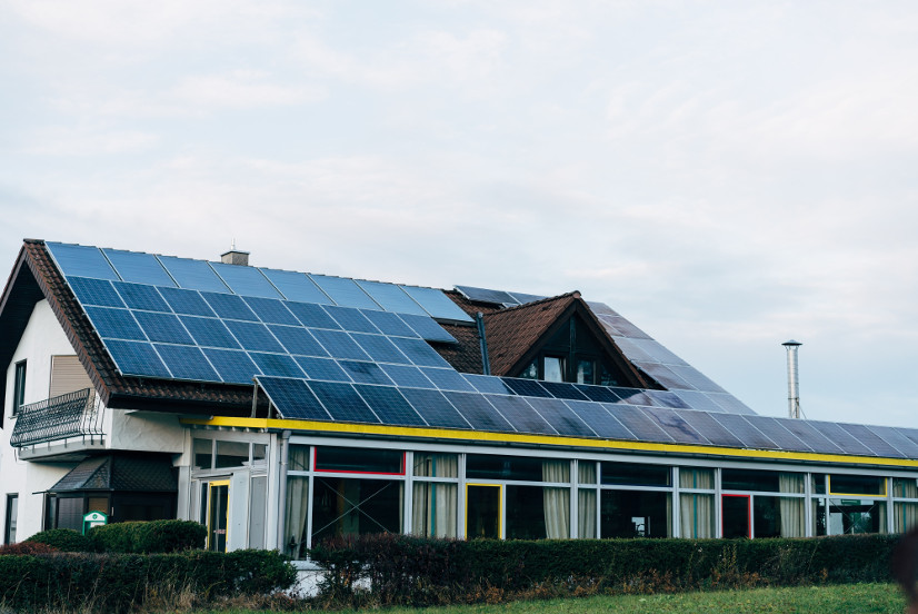 A two-story house with almost the entire roof covered in solar panels.
