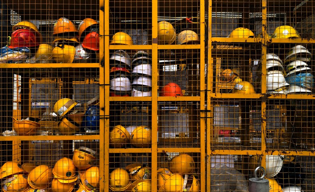 image of a yellow construction safety equipment locker. the locker is filled with construction site safety helmets