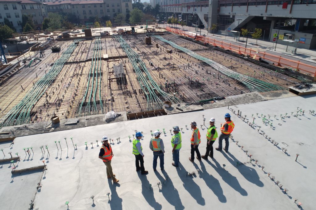 image of a construction site project team wearing high-visibility vests having a conversation