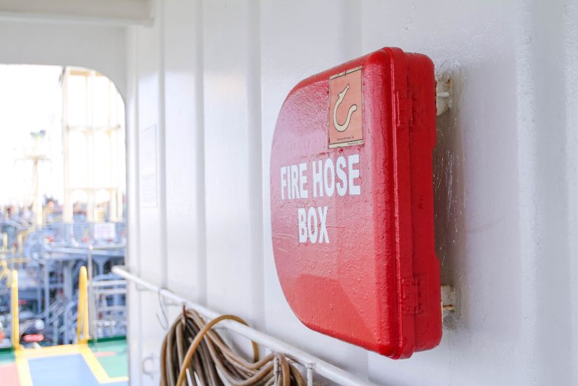 image of a red fire hose safety box on a wall